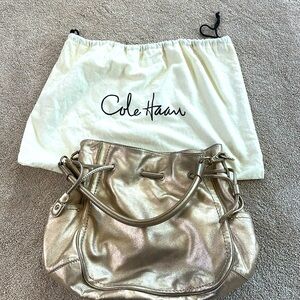 Gold Cole Haan Purse. Sides pockets and internal pockets. Pull string/magnet.